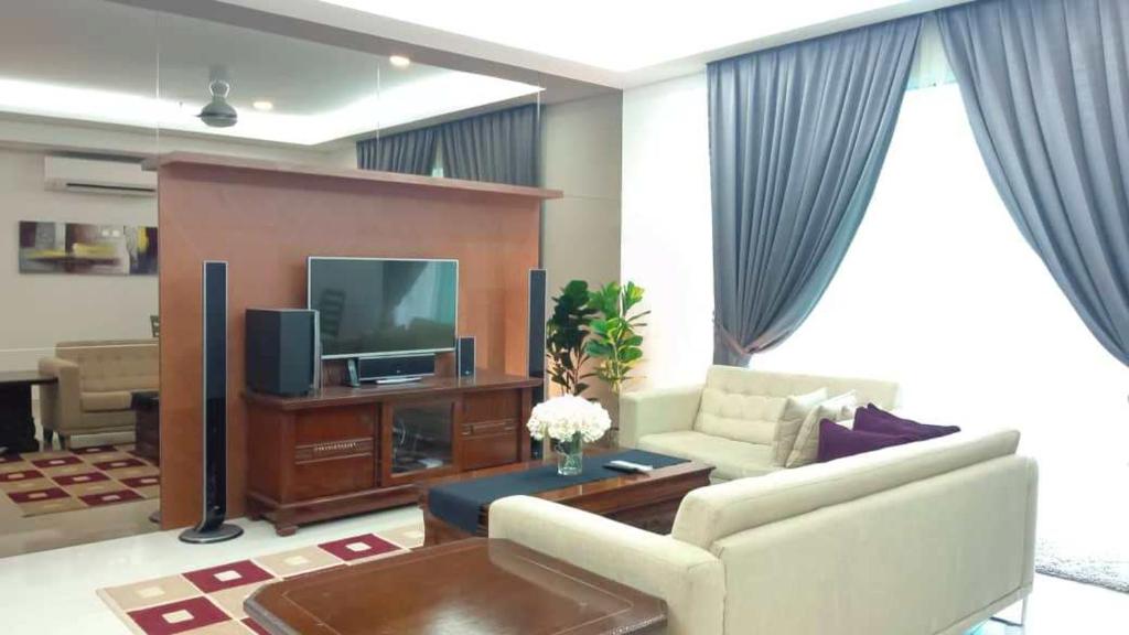 a living room with a couch and a tv at Tamu Apartment Kuala Lumpur by Q Luxe in Kuala Lumpur