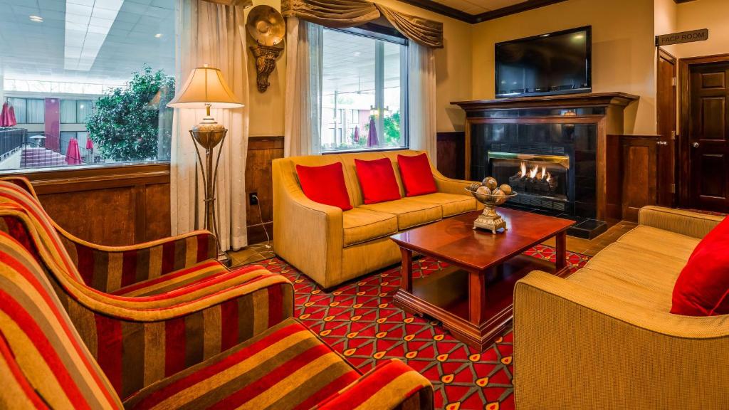 a living room with a couch and a fireplace at Best Western Plus Burlington in Burlington