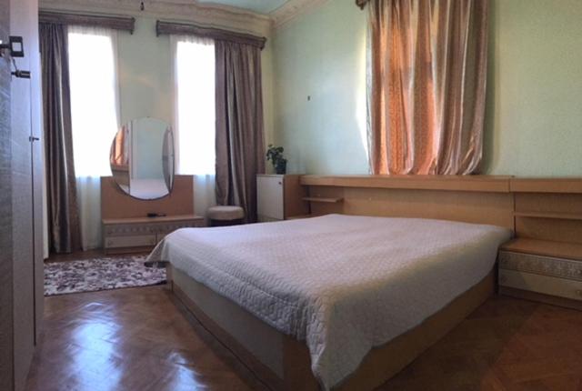 1 dormitorio con 1 cama y TV. en Hause en Tskaltubo