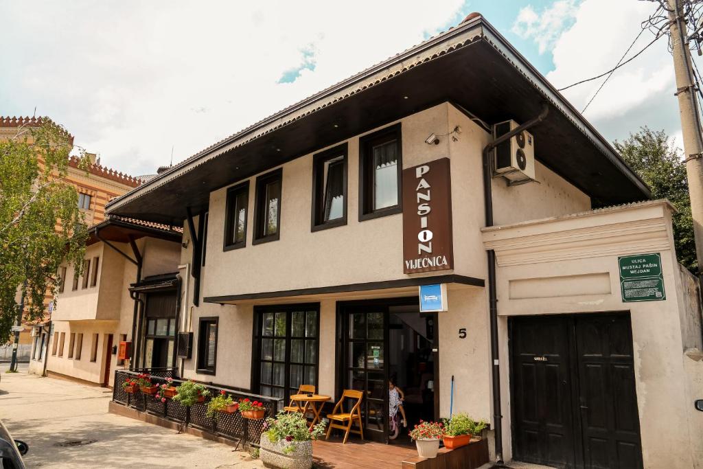 un edificio con ristorante in una strada cittadina di Bed and Breakfast Vijecnica a Sarajevo