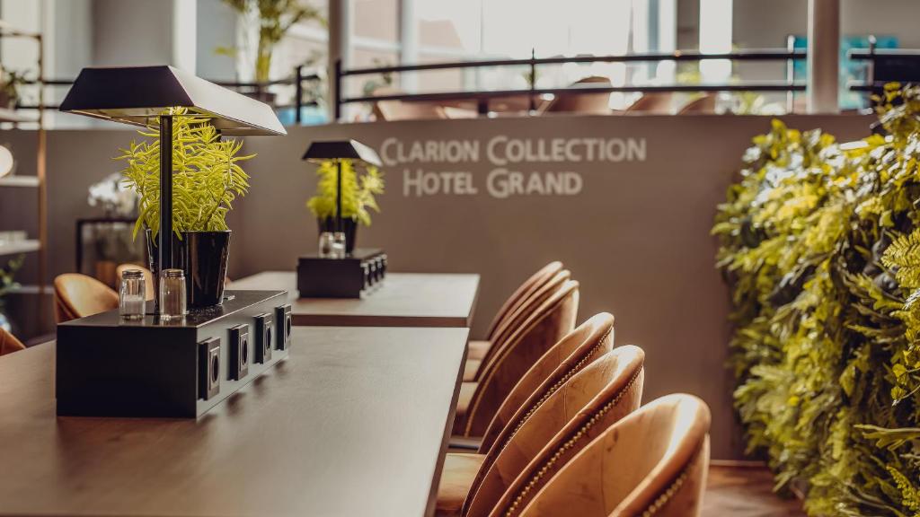 Clarion Collection Hotel Grand Bodø في بودو: قاعة اجتماعات مع كراسي وطاولة مع مصباح