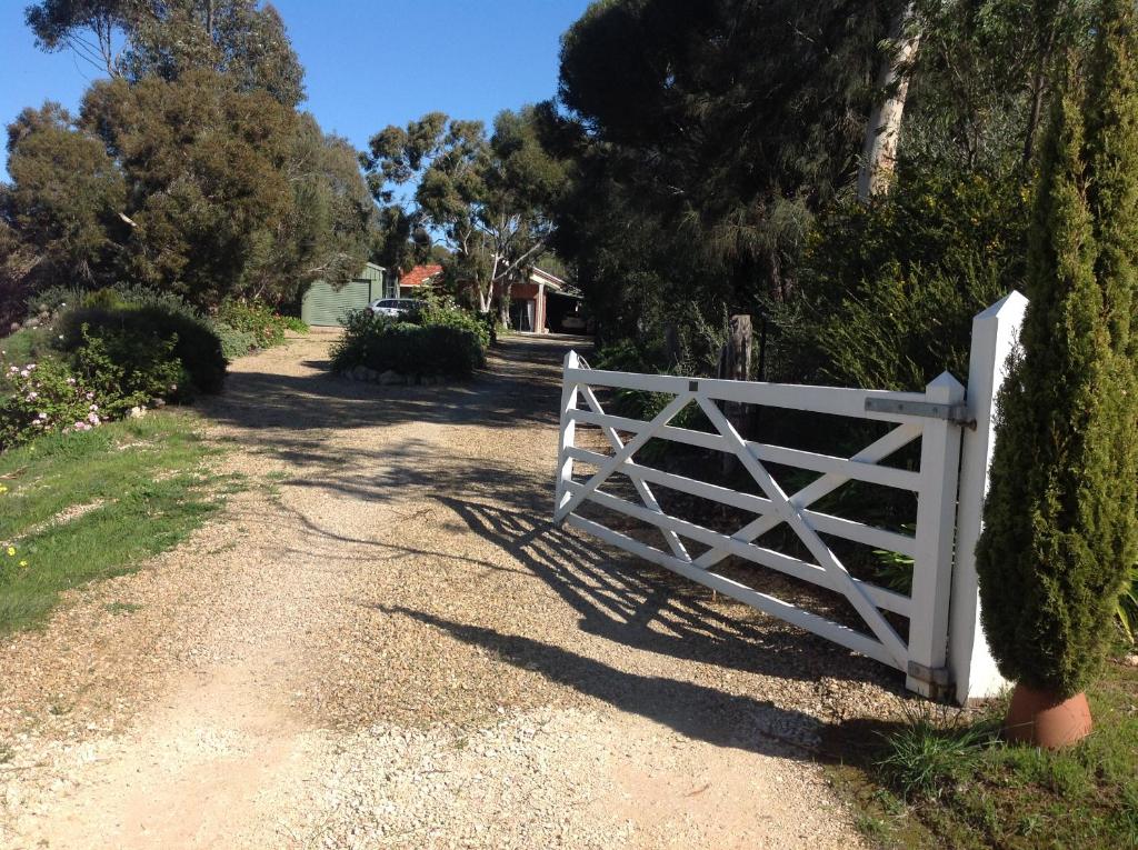 a white gate on the side of a dirt road at Port Elliot rural retreat in Port Elliot