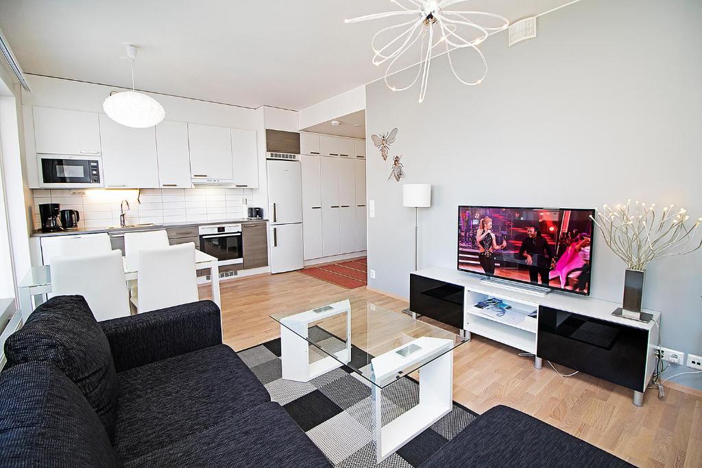 a living room with a couch and a tv at Pro Apartments 5 in Vaasa