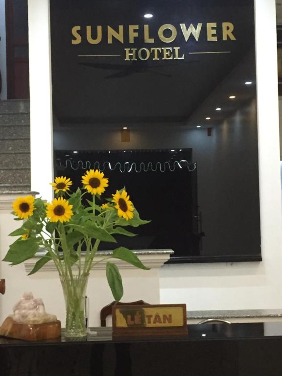 a vase of sunflowers on a table in front of a mirror at Sunflower Hotel in Ninh Binh