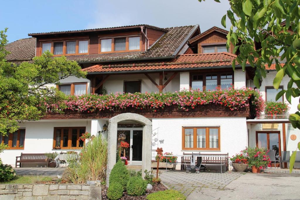 una casa con flores a un lado. en Pension Zum Ebenstein am Donausteig, en Untergriesbach