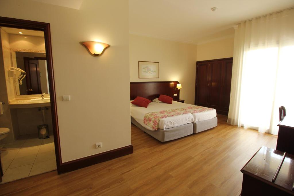 Postel nebo postele na pokoji v ubytování Suite Hotel Jardins Da Ajuda