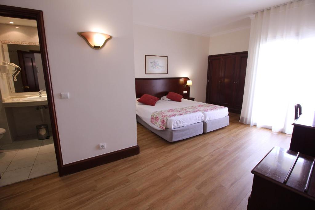 Postel nebo postele na pokoji v ubytování Suite Hotel Jardins Da Ajuda