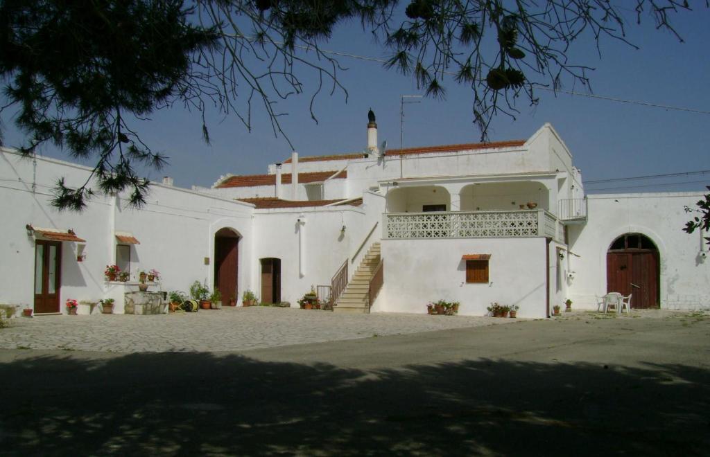 a white building with a staircase in front of it at Masseria Cassiere in Mottola