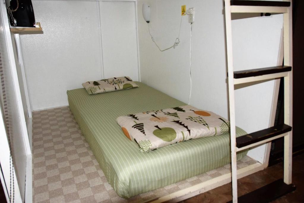 Kumoji-so Hostel في ناها: غرفة بسريرين بطابقين في غرفة