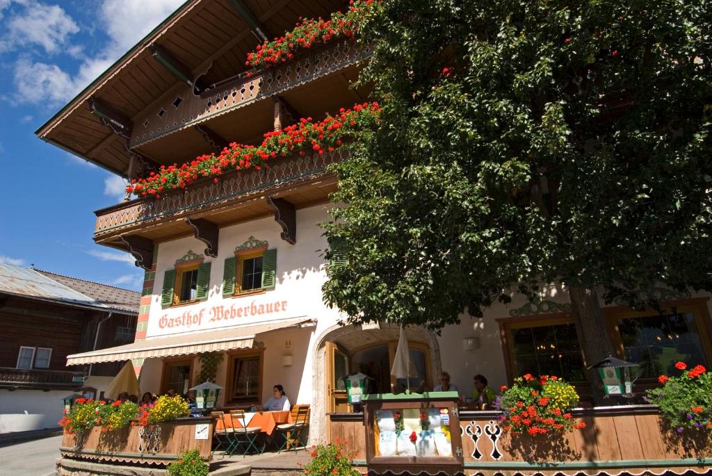 un edificio con dei fiori sul lato di Gasthof Weberbauer a Scheffau am Wilden Kaiser