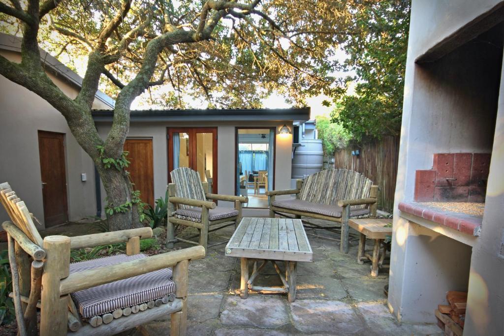a patio with chairs and a table and a tree at Grants Place in Wilderness