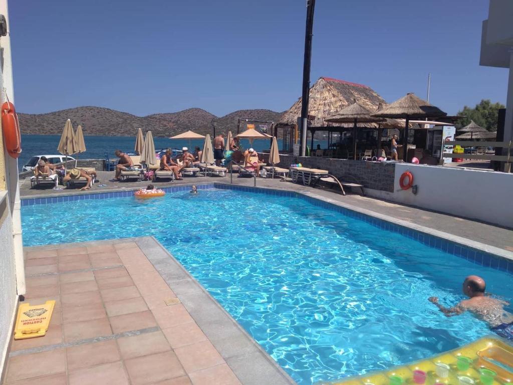 a large swimming pool with people in the water at Hiona Apartments in Elounda