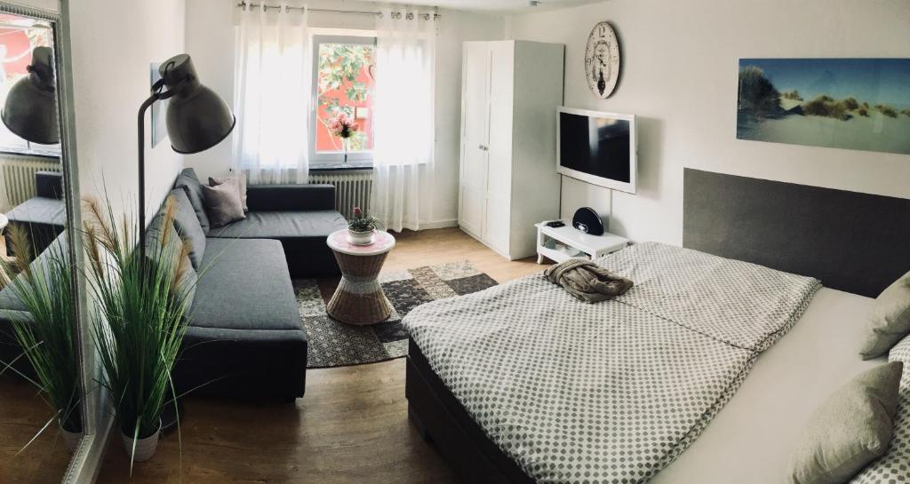 a living room with a couch and a tv at Apartment Karlsruhe, Grünwinkel, Messe nähe in Karlsruhe