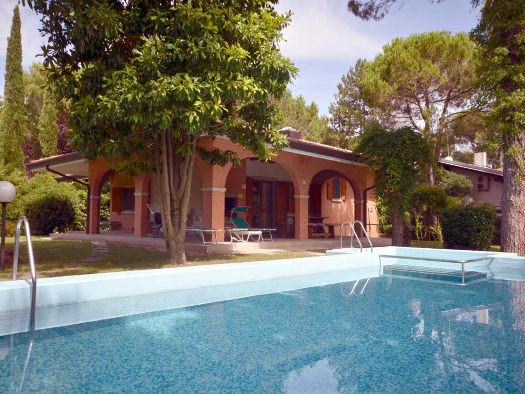 ein Haus mit einem Pool vor einem Haus in der Unterkunft Villa Sabrina in Lignano Sabbiadoro