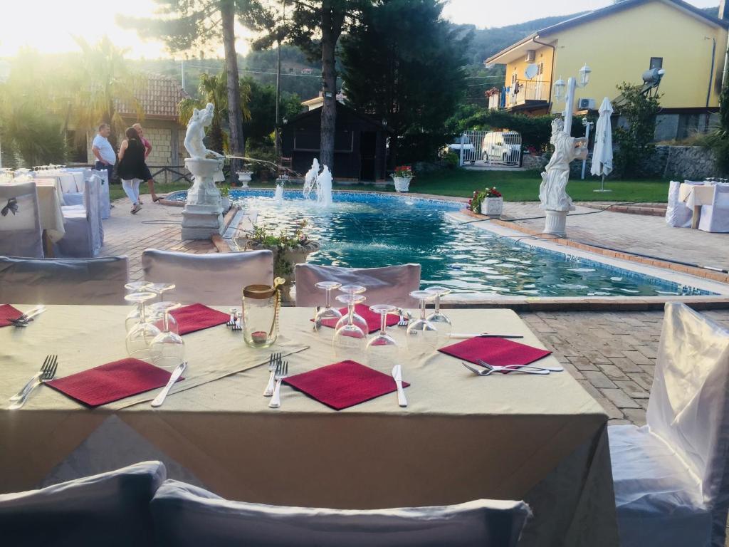 a table set up for a wedding in front of a swimming pool at Hotel Bucolia in Lamezia Terme