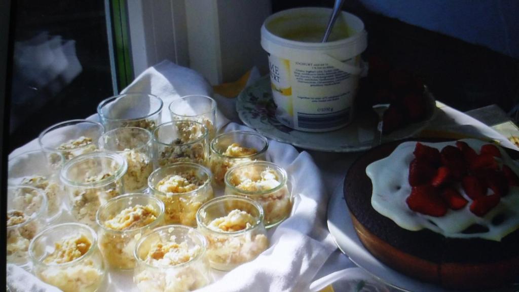 a table with cups and a cake and a bucket at Villa Jani b&amp;b in Breitscheid