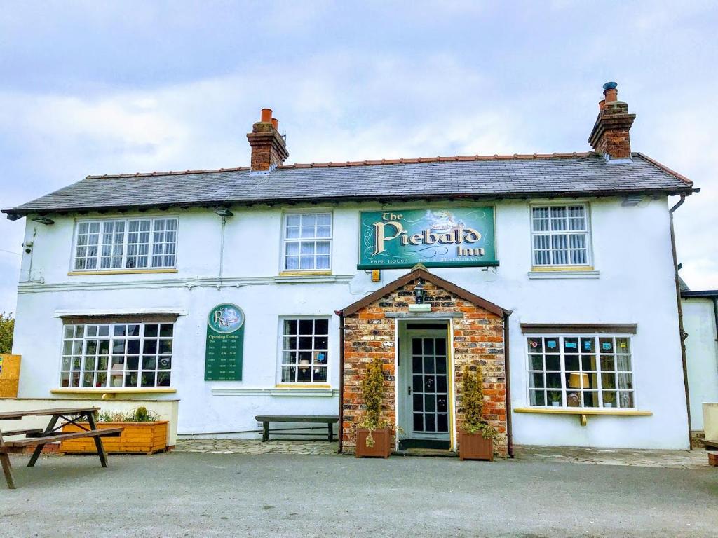 um edifício branco com uma mesa de piquenique em frente em The Piebald Inn em Hunmanby