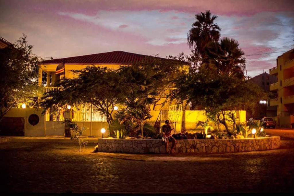 a person standing in front of a building at night at Surf House Hostel in Santa Maria