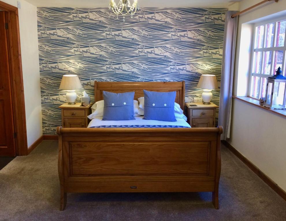 een slaapkamer met een bed met blauwe kussens bij Sanders Yard in Whitby