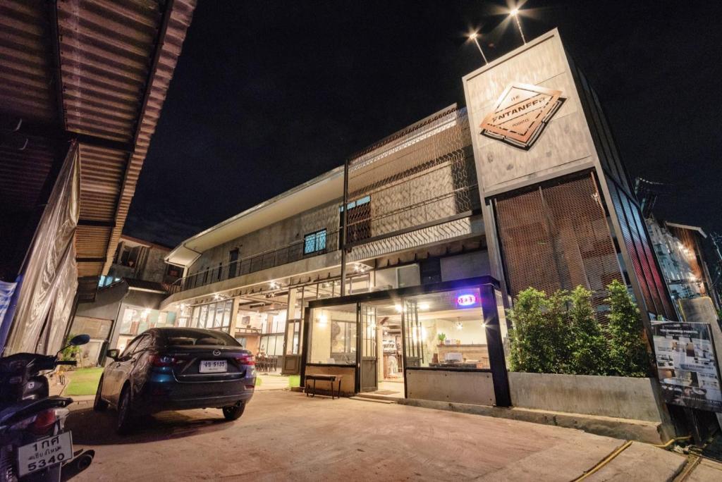 チェンマイにあるザ エンタニア ポシュテルの夜間の建物前に停車する車