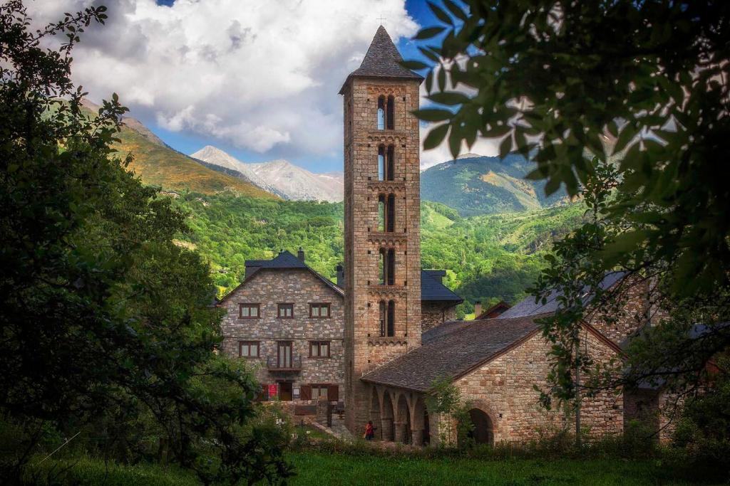 an old stone building with a tall tower at Hostal La Plaça in Erill la Vall