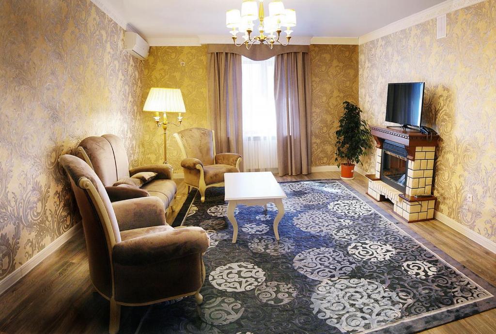 uma sala de estar com sofás e uma televisão em Tumar Hotel em Aqtöbe