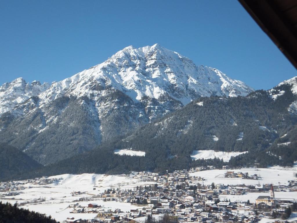 a snow covered mountain with a town in front of it at Haus Gantioler in Mieders