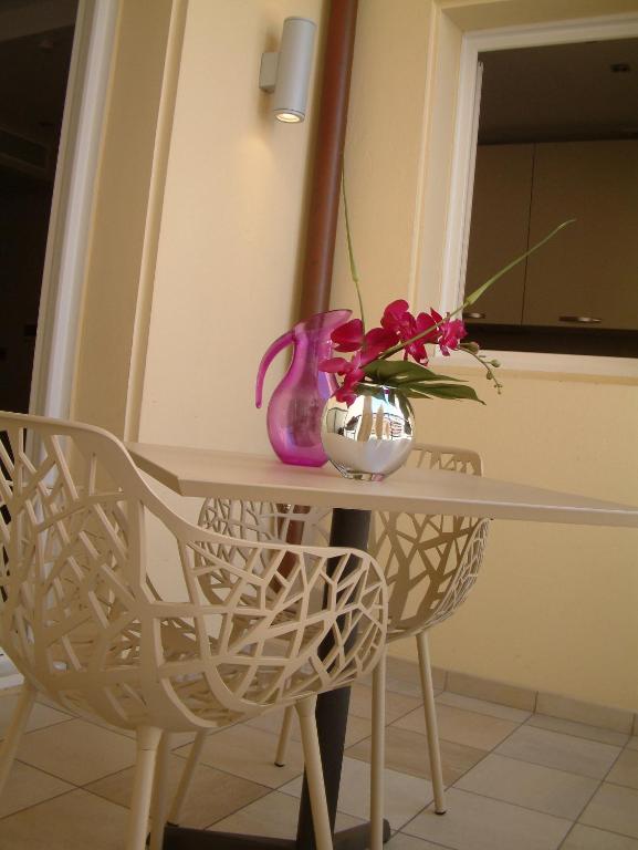a table with a vase and flowers on it at Hotel Villa d'Elsa in Juan-les-Pins