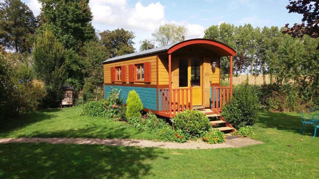 a small house in the middle of a yard at Roulotte Gabi in Rouville