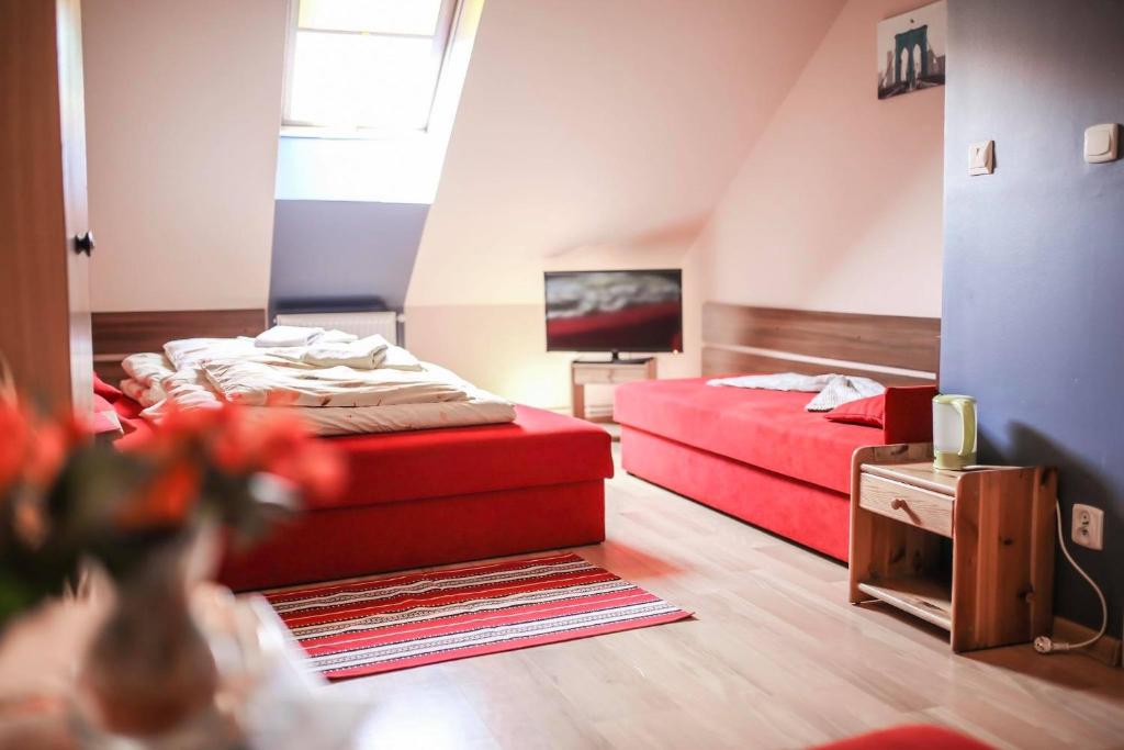 カルヴァリア・ゼブジドフスカにあるAparthotel "DZIEWIĘTNASTKA"のベッドルーム1室(ベッド2台、赤いソファ付)