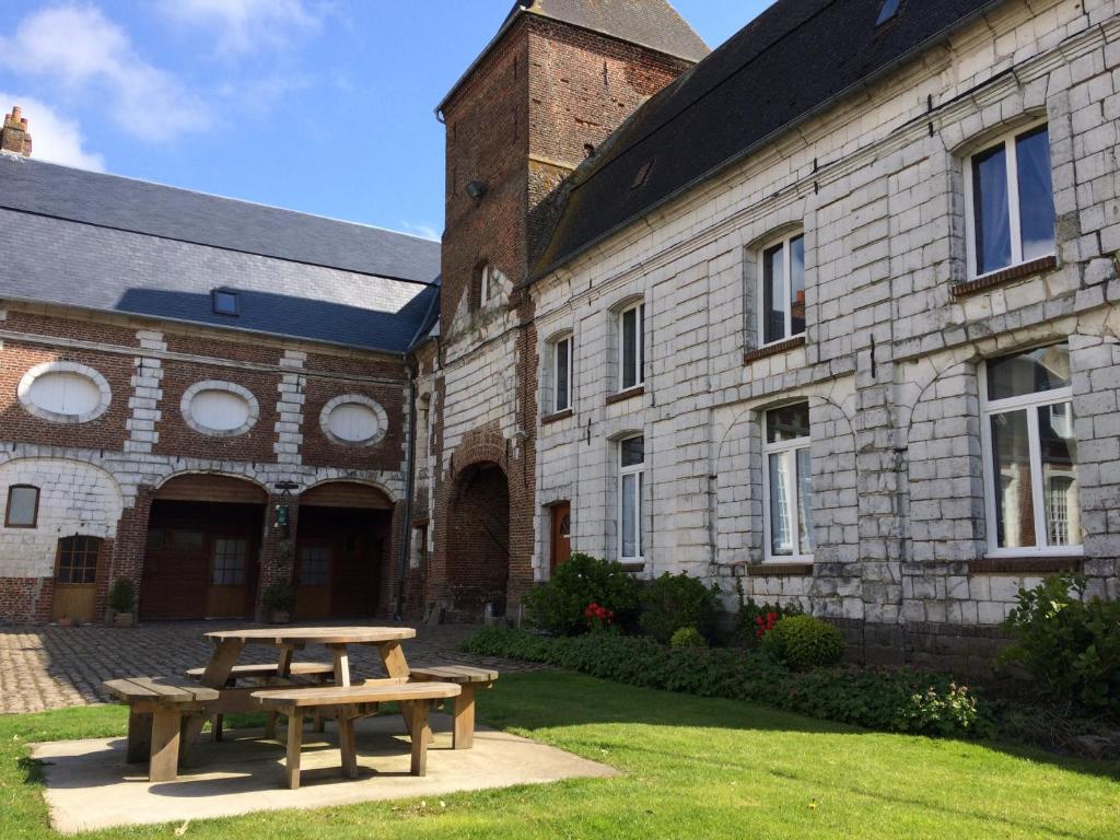 a picnic table in front of a brick building at le chateau de PENIN in Penin