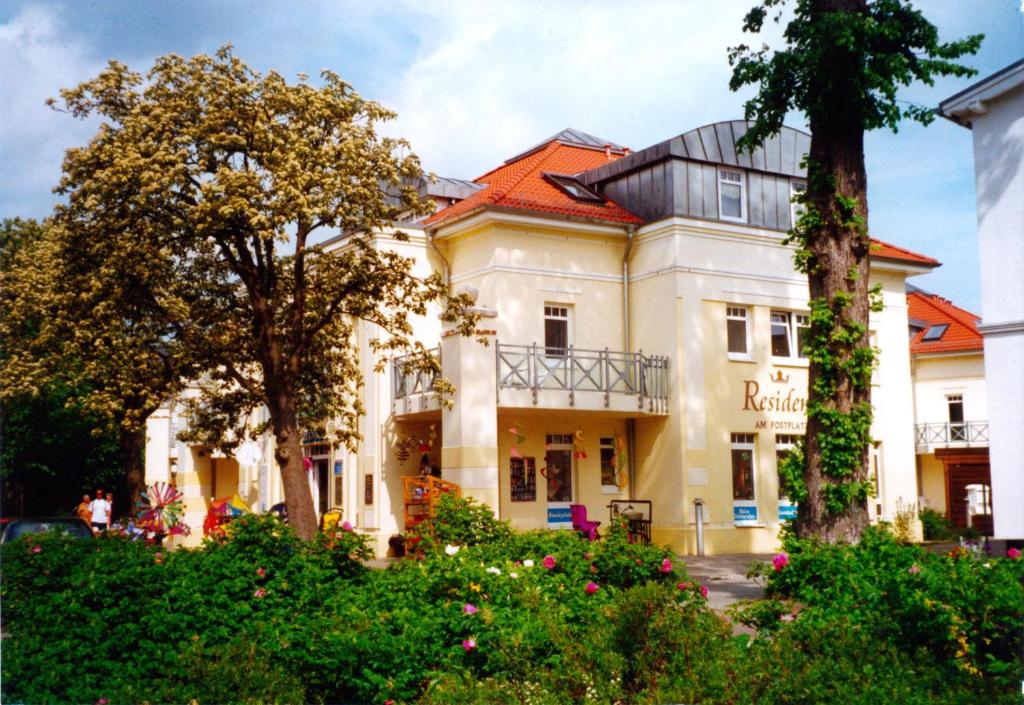 a building in a park with trees and flowers at Villa Nadine, gemütliche Ferienwohnung in Zingst