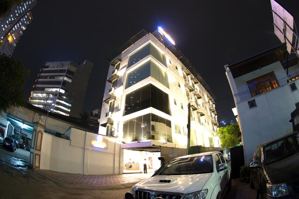 une voiture blanche garée devant un bâtiment la nuit dans l'établissement City Hotel Colombo 02, à Colombo