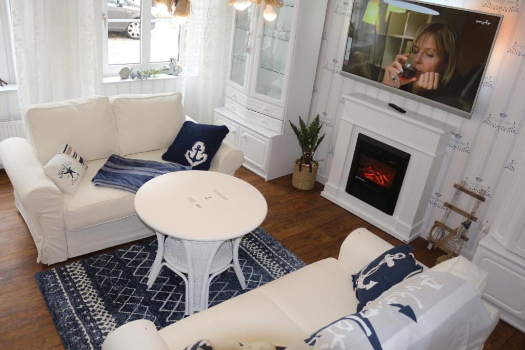 uma sala de estar com mobiliário branco e uma televisão em Dompanorama- Luxuriöse FeWo em Havelberg