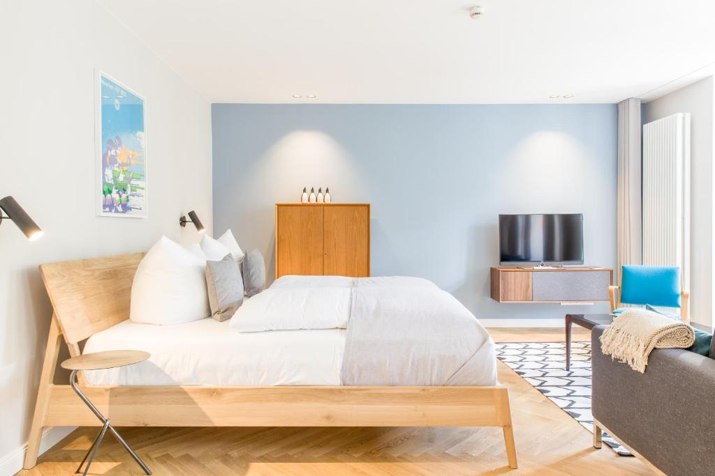 a bedroom with a large bed and a couch at OSTKÜSTE - Nadler Hof Design Apartments in Ahlbeck