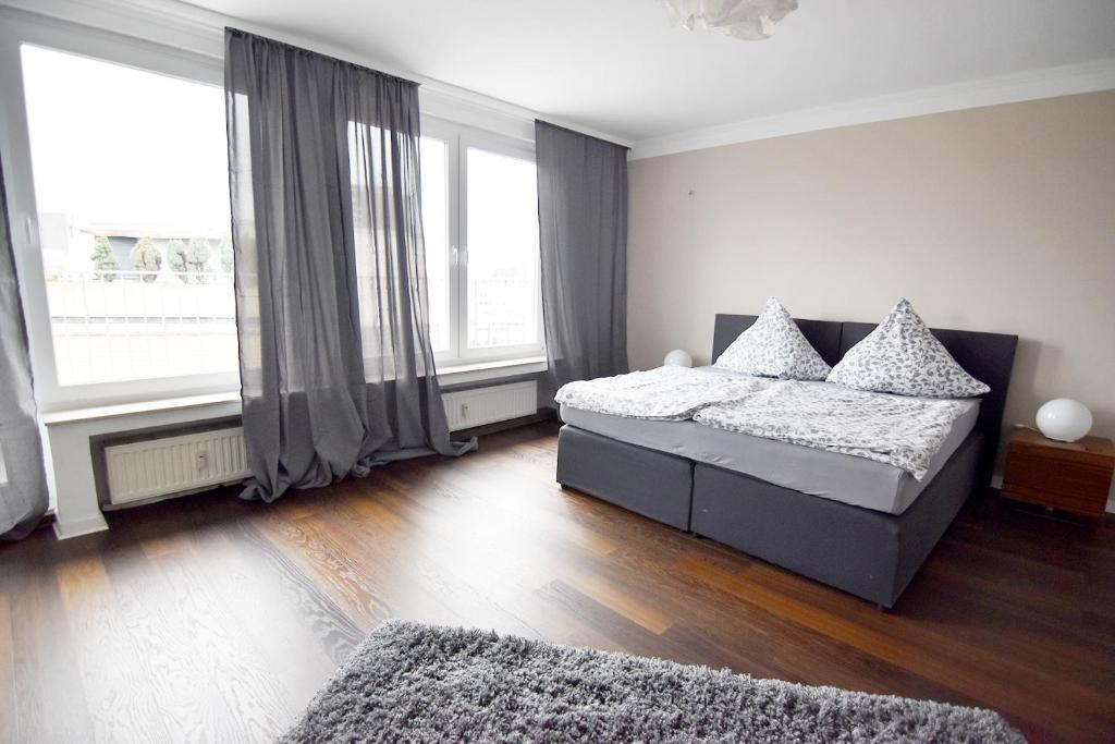 a bedroom with two beds and large windows at Dorya am Ring in Cologne