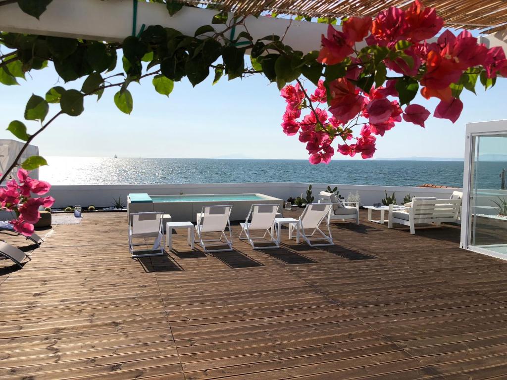 un patio con sedie, tavolo e vista sull'oceano di La Chiaja art&relais a Castellammare di Stabia
