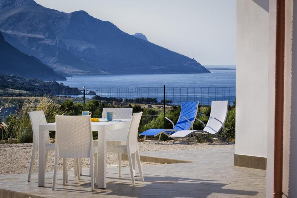 a table and chairs with a view of the ocean at Villa Gloria in Castellammare del Golfo