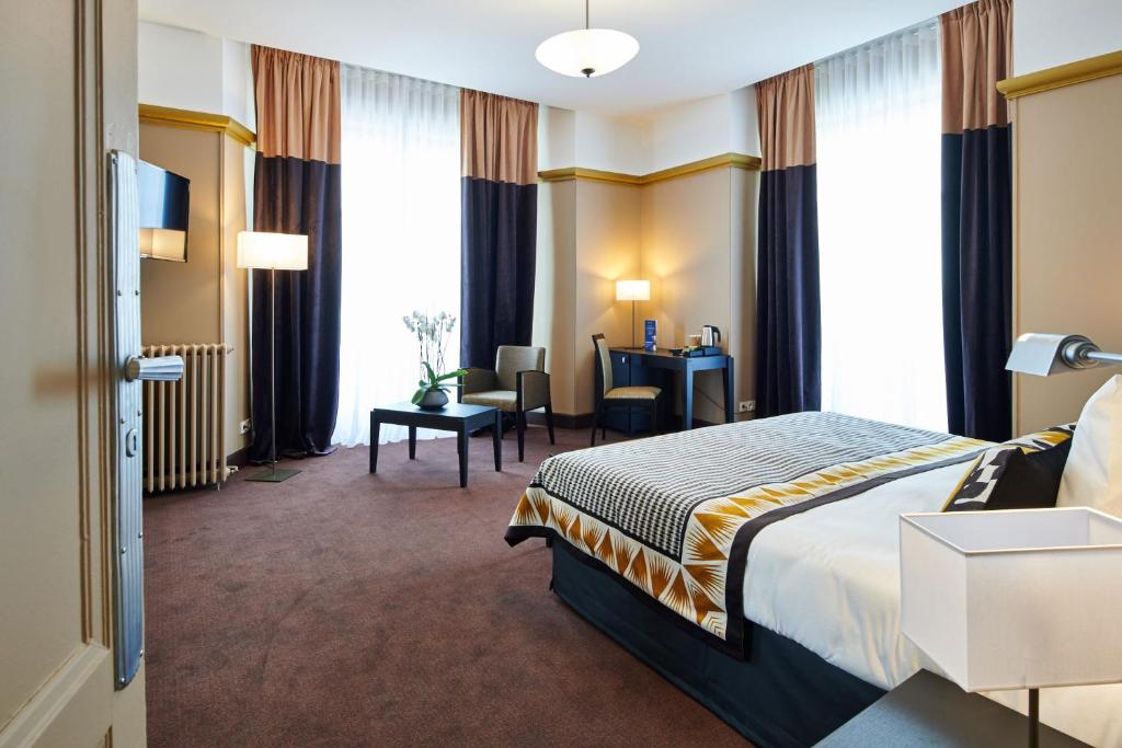 a hotel room with a bed and a desk at Hotel &amp; Spa Vacances Bleues Le Splendid in Dax