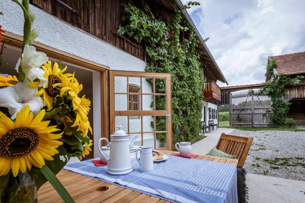 een tafel met een vaas met zonnebloemen erop bij Landhaus Holzen in Pfarrkirchen