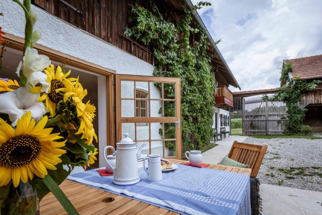 uma mesa com um vaso de girassóis em cima em Landhaus Holzen em Pfarrkirchen