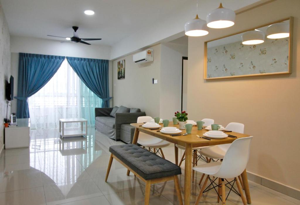 een eetkamer en een woonkamer met een tafel en stoelen bij H2H - Eleven4 Majestic Ipoh in Ipoh
