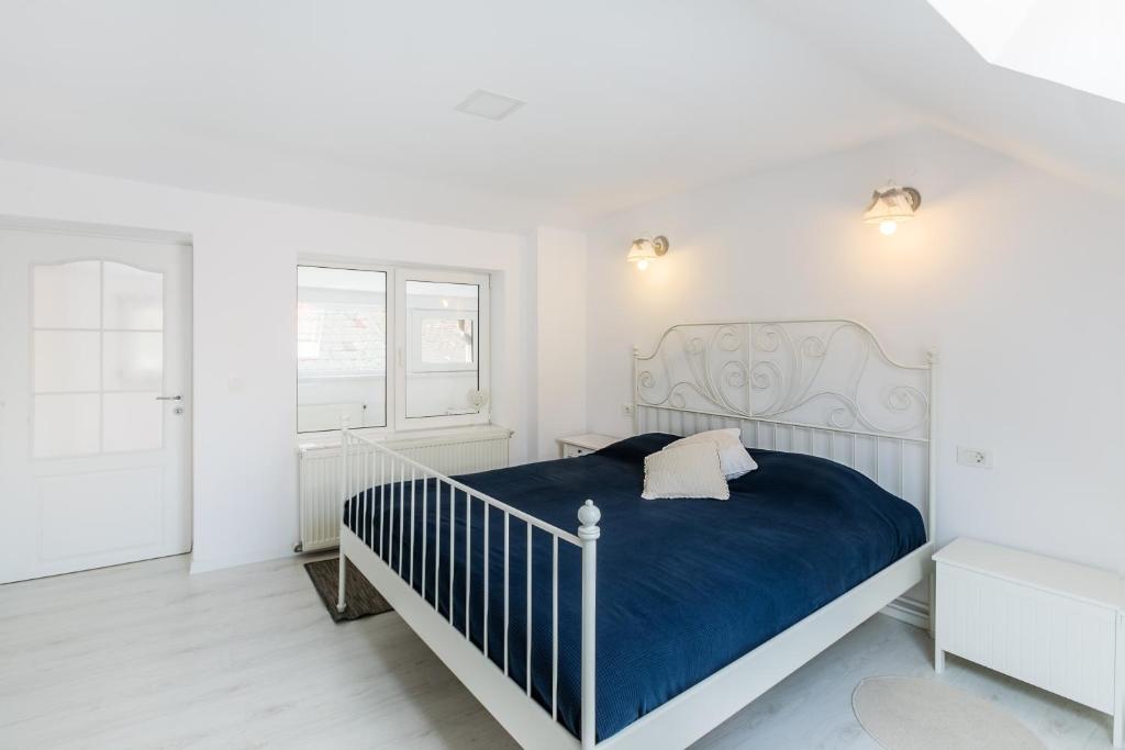 1 dormitorio blanco con 1 cama y 2 ventanas en Kendall Studio, en Brasov