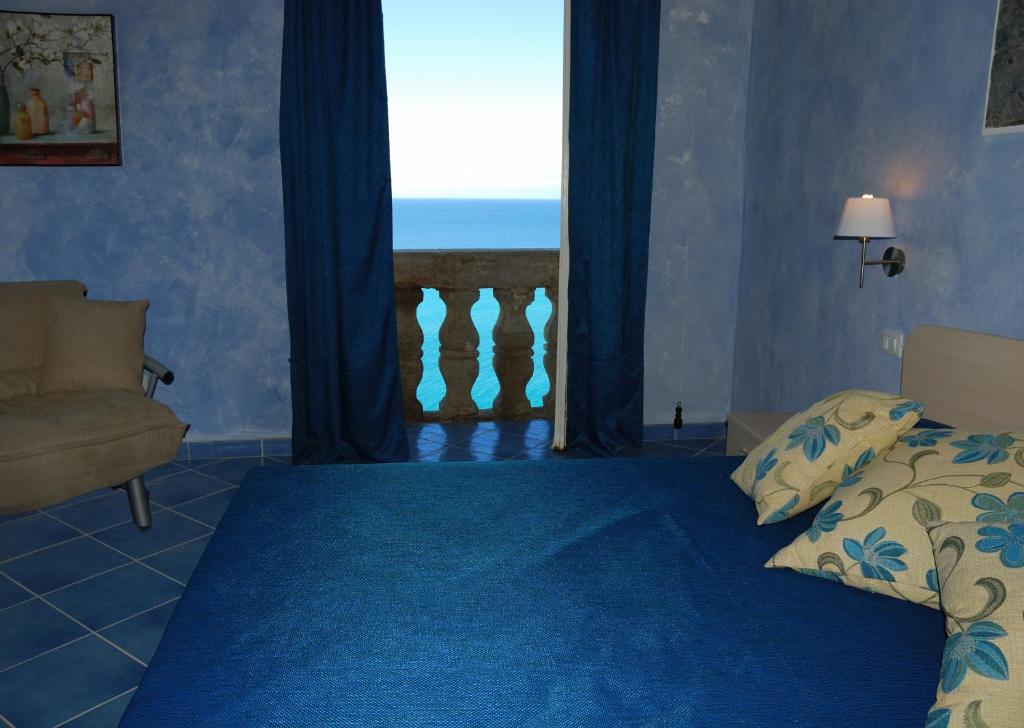 1 dormitorio con cama y vistas al océano en Blu Tropea Maison, en Tropea