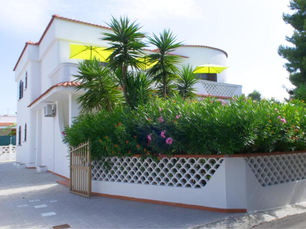 una casa blanca con palmeras y flores en Villa Elvira, en San Pietro in Bevagna