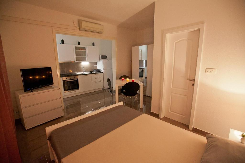 1 dormitorio pequeño con 1 cama y cocina en Apartman 2, en Zadar
