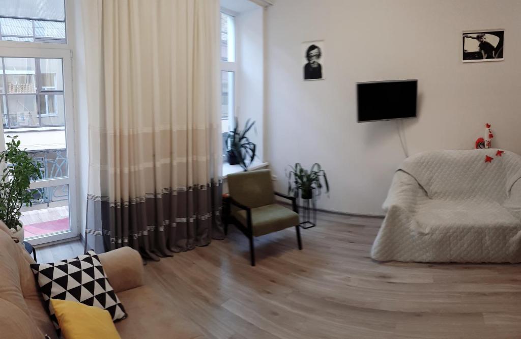 a living room with a couch and a chair and a television at Apartment - Heart of Odessa in Odesa