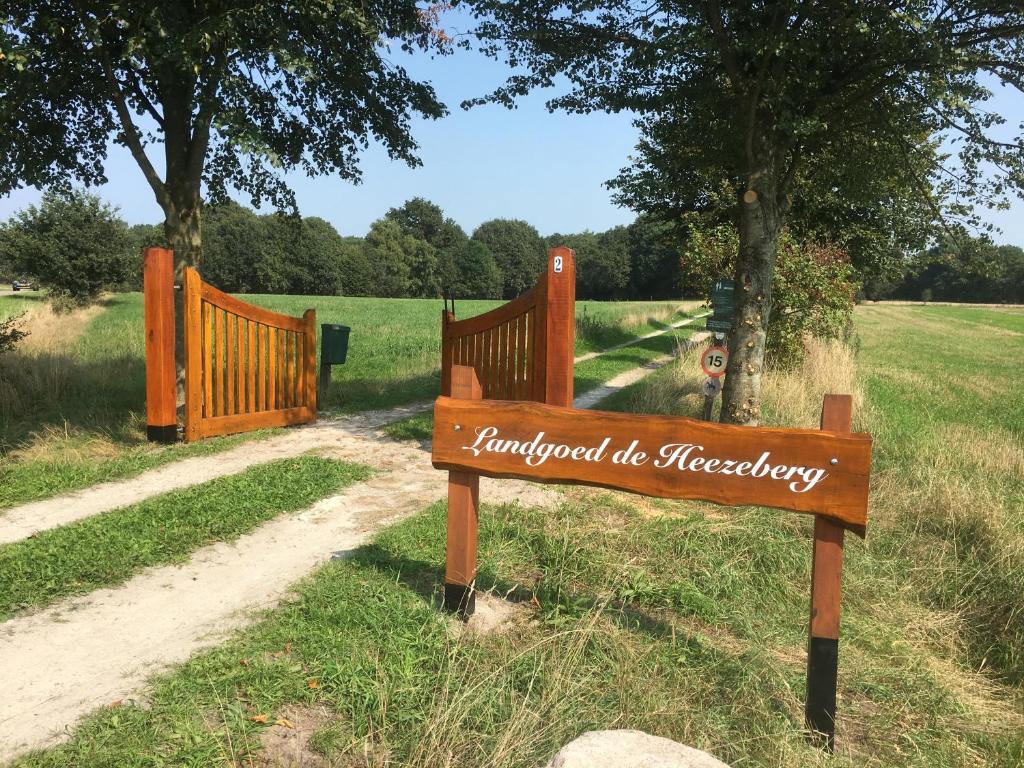 een houten bord in het gras naast een hek bij Landgoed De Heezeberg in Diever