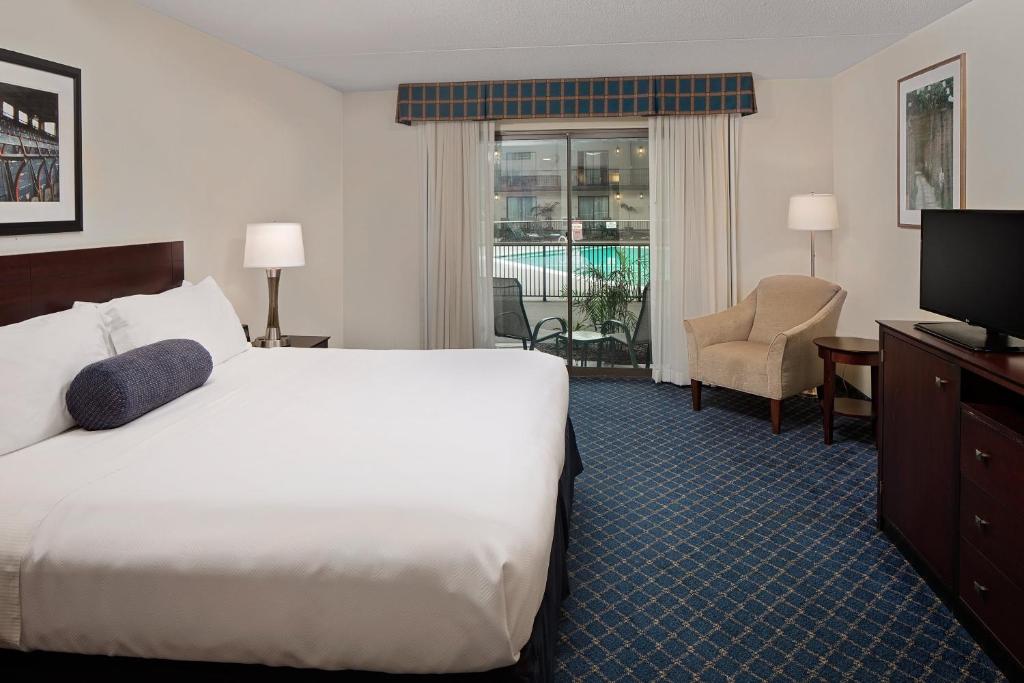 a hotel room with a bed and a television at Boxboro Regency in Boxborough