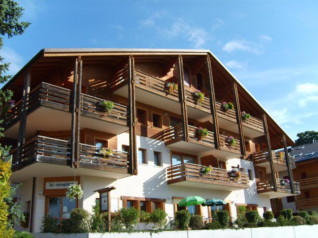 ein Gebäude mit Balkonen und Pflanzen darauf in der Unterkunft Résidence Castel Club Leysin Parc in Leysin